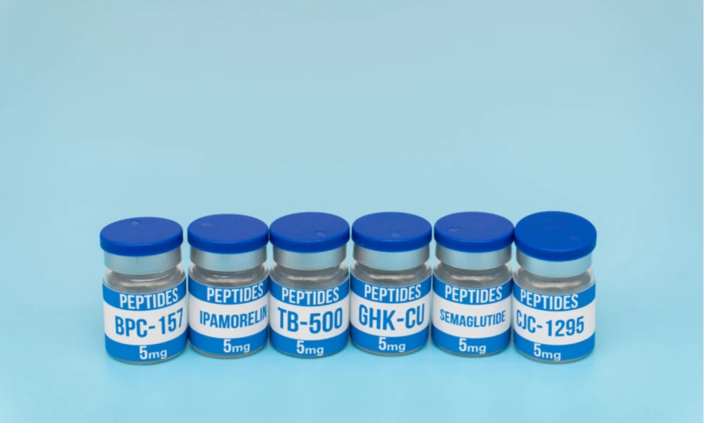 Six research peptide vials with labels on a clean laboratory background.
