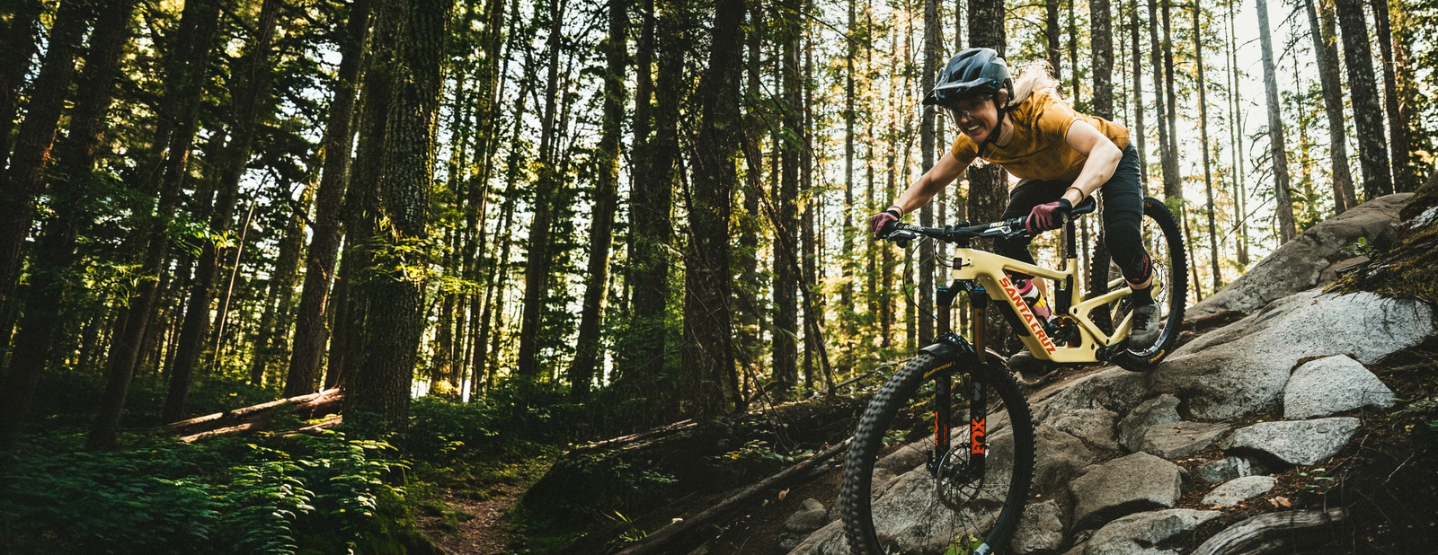 A woman riding a mountain bike on rocky descent
