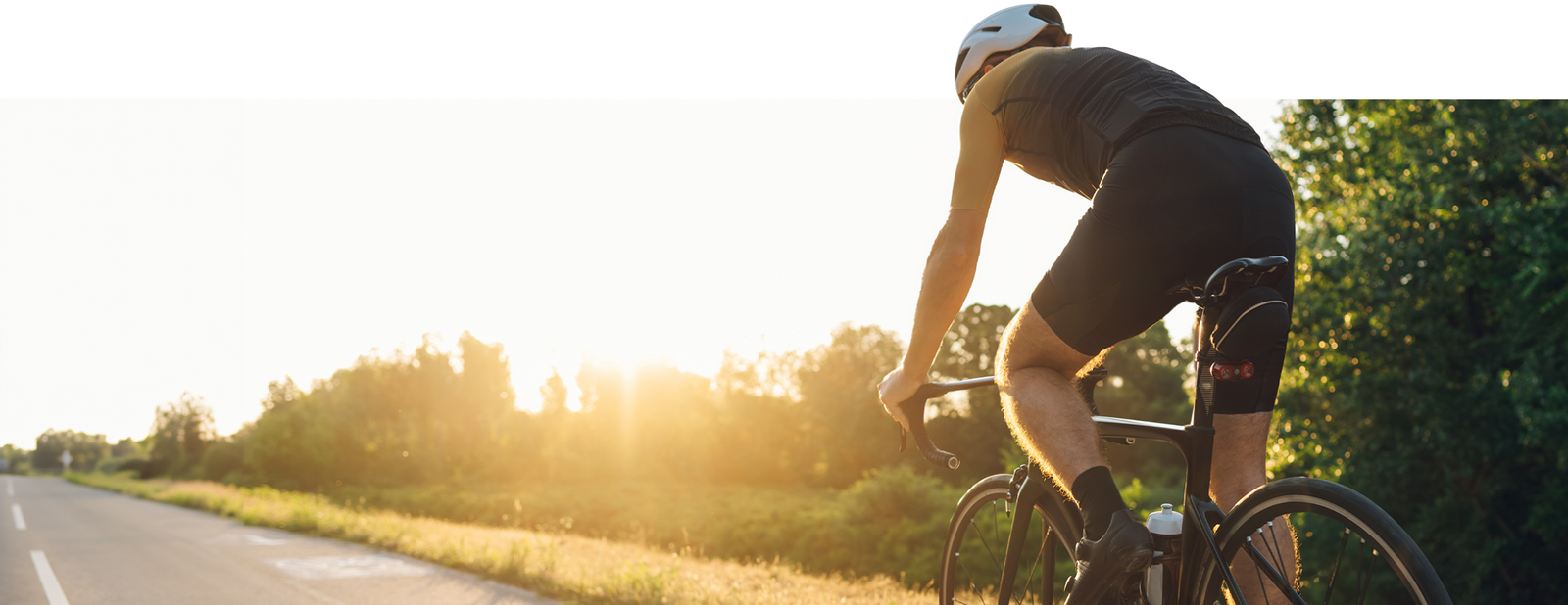 Cyclist cycling in to the sunset with cycler bicycle insurance