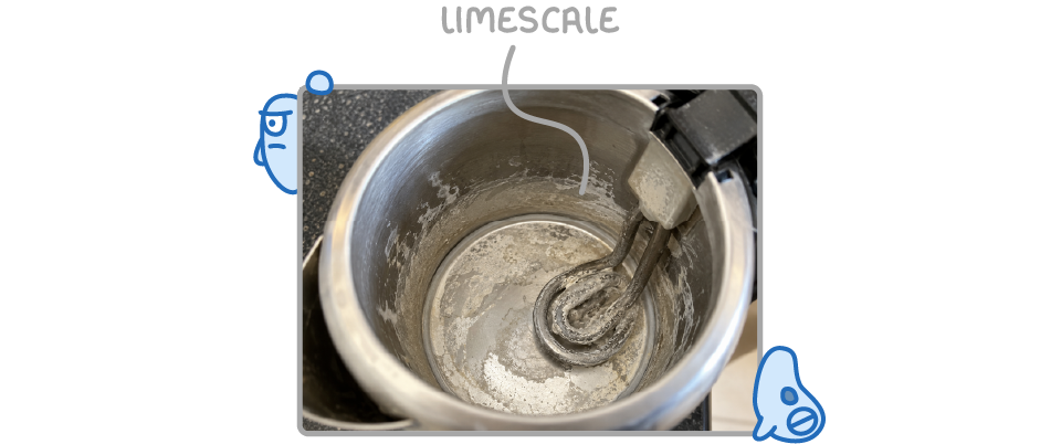 A photograph looking into a kettle, with a white crust labelled limescale coating the inside and the heating element.