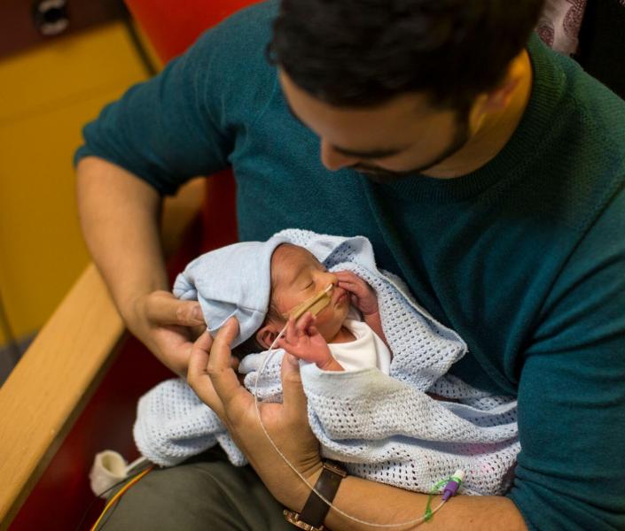 Dad holding baby in hospital