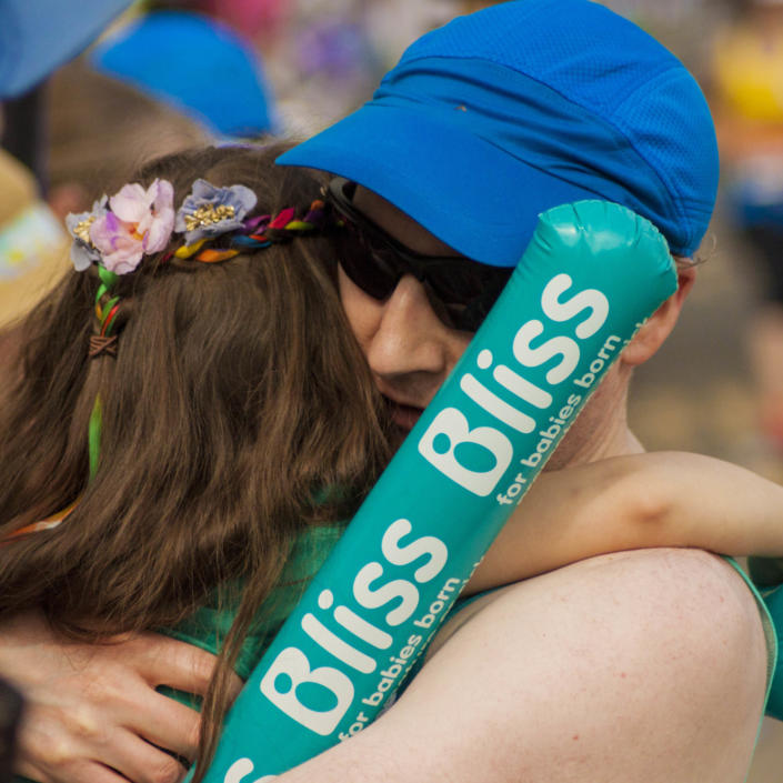 Man taking part in running event hugging a Bliss supporter