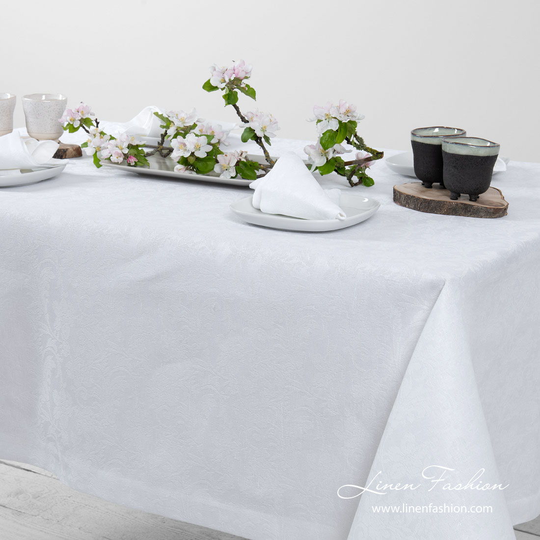 White linen tablecloth with flower ornaments, folded border