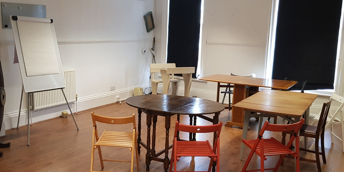 Meeting room with round tables and a flip chart