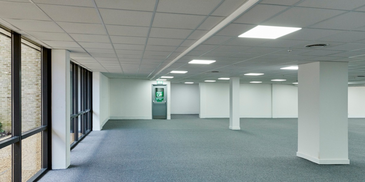 Open-plan office floor with full-height windows