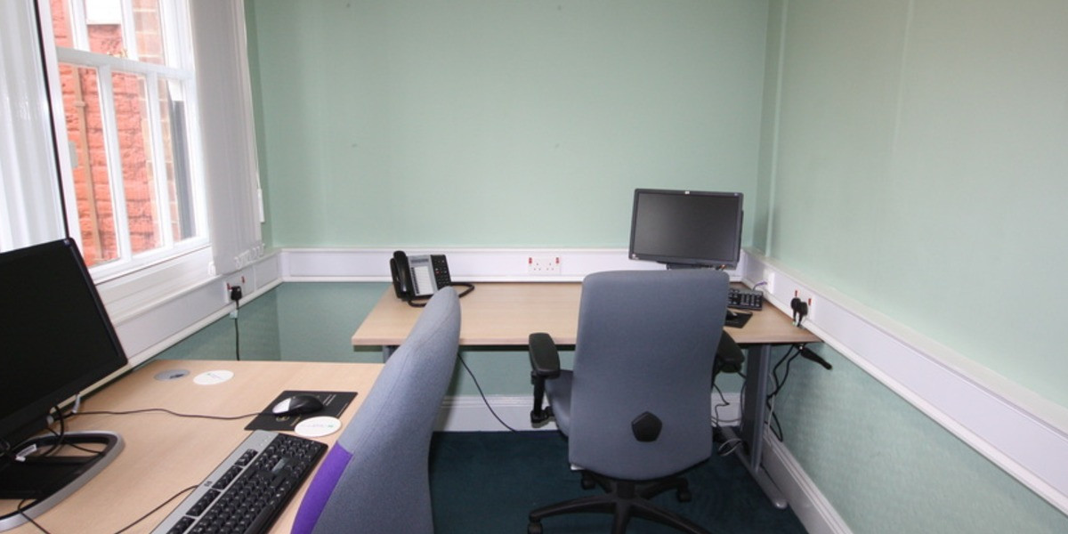 Furnished private office with desks and sash windows