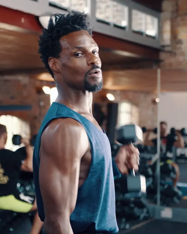 A man in a gym glancing at his phone