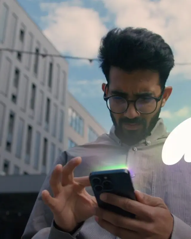 A man checking his phone on a city street