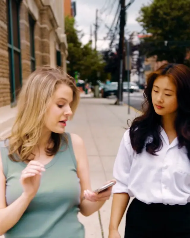 Two women walking and talking on a city street
