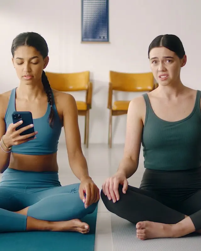 Three women seated on yoga mats
