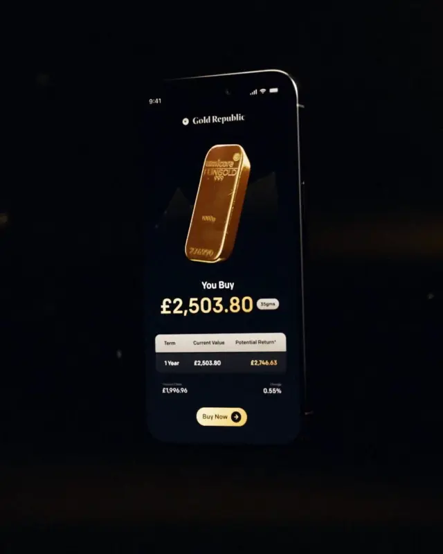 A phone showing a gold holding balance, lit from below on black