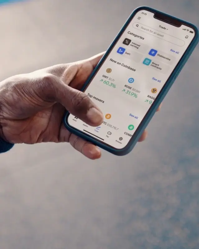 A hand holding a phone in a gym