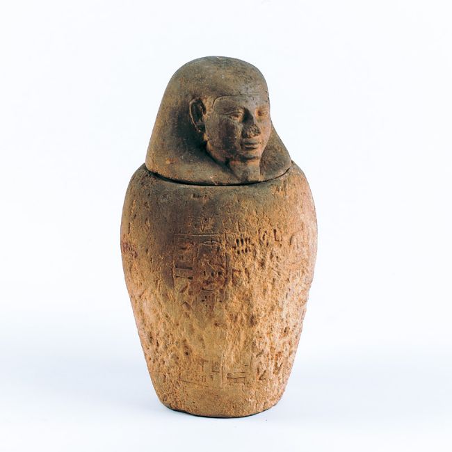 Carved stone jar with lid carved in the shape of a human head.