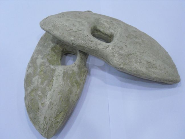 Lozenge shaped stone weights with holes drilled through the middle for attachment