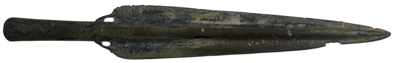 Bronze spearhead with a hollow socket at the base. The blade is elongated and tapers to a sharp point. The surface shows patches of dark and greenish corrosion.