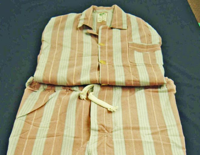 Folded pair of men's pyjamas with peach and white stripes