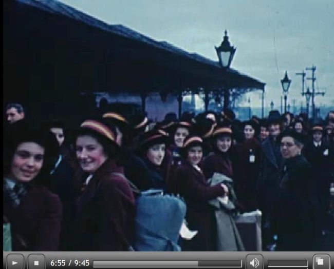 Film still of Hull girls at a railway station being evacuated during WW2