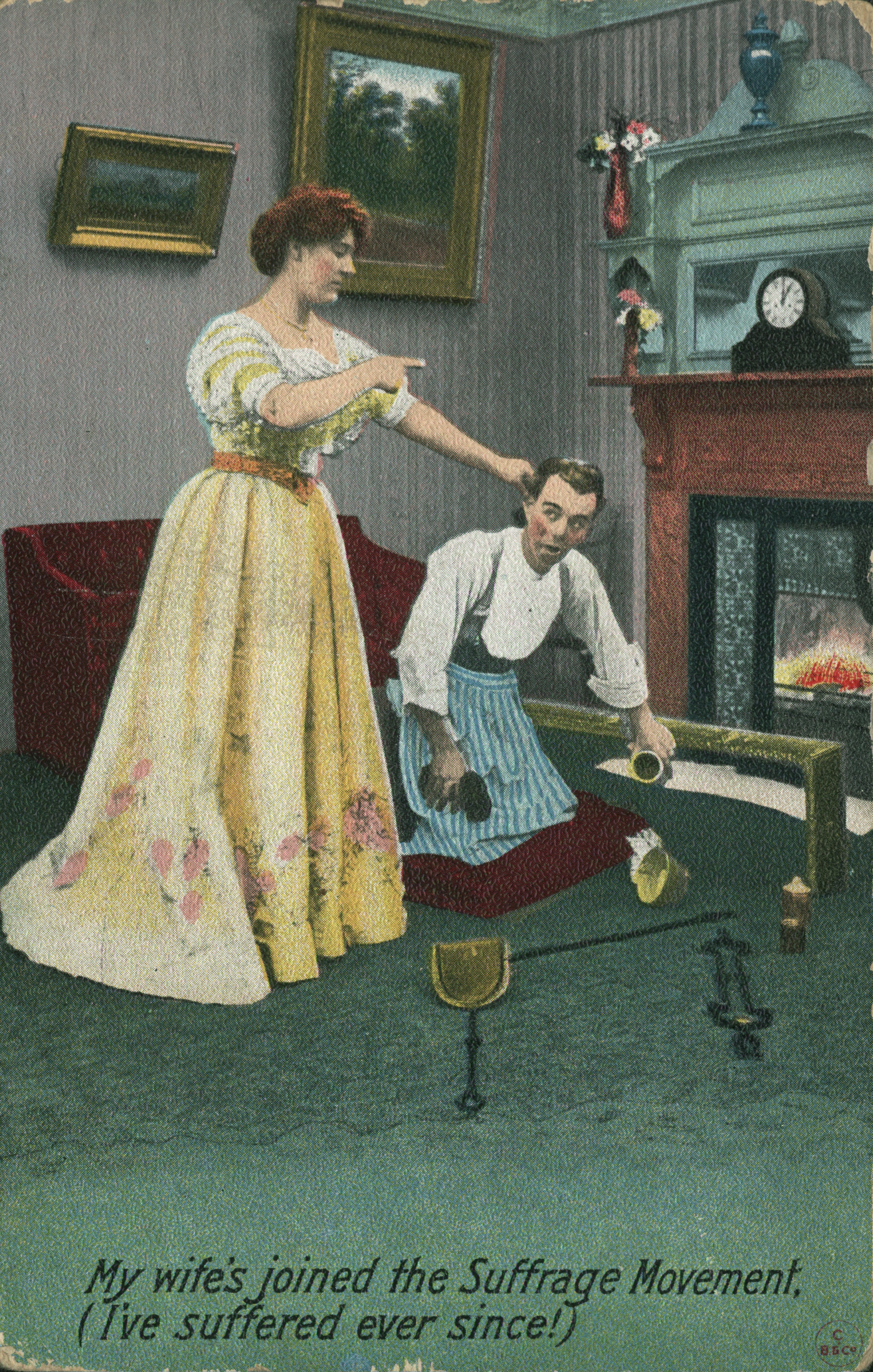A vintage illustration of a woman in a yellow dress holding a man by the ear. The man kneels, holding broken cups on a green carpet by a fireplace. The caption reads: "My wife's joined the Suffrage Movement. (I've suffered ever since!)"