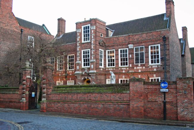 A large brick building with chimneys at either end.