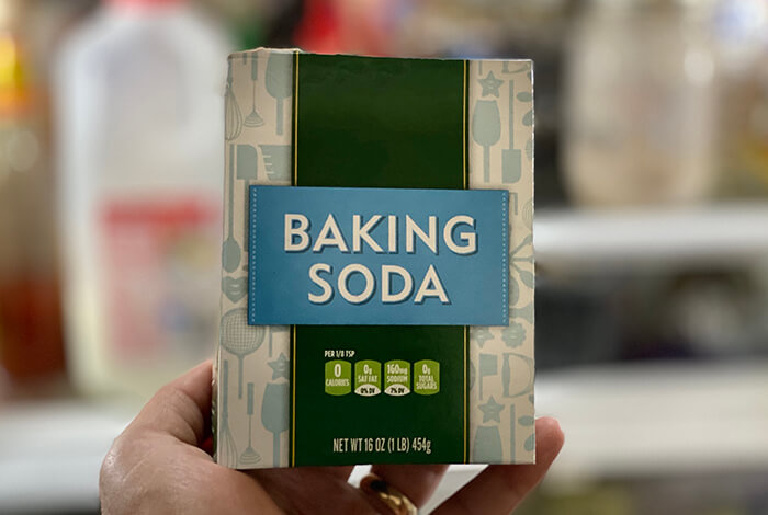 a person holding a box of baking soda