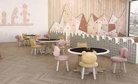 Pause & Play Lounge | colorful kids playroom in shades of sorbet with Bonbon blush pink chair, Baloo yellow chair, Marshmallow dark and grey activity II table, climbing wall, and wood flooring