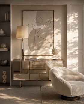 Living Room | spring/summer reading corner in cosy neutral style with Kafe glass sideboard for storage, Winnow table lamp, curvy retro white armchair, and wall art