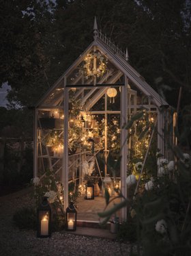 Spring Evening Garden Shed with Glowing Fairy Lights, Easter Wreath, Festoon Lanterns & TruGlow® Outdoor Candles