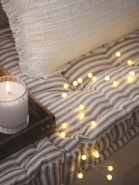 Cosy Window Bench with glowing Pearl Micro LED Battery Cluster Lights and TruGlow® LED candle