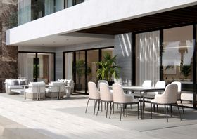 Outdoors | outdoor garden area with Charla dining chair, dining table, grey rug, vase, and wood flooring