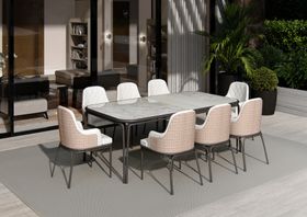 Outdoors | outdoor garden area with Charla wood dining chair, Charla marble dining table, grey rug, and vase