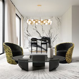Open Space | black and white living room and kitchen island in marble finishes with Bloom curvy yellow leopard print armchair, Nahema dark bar stool, Hera gold suspension lamp, and glass center table