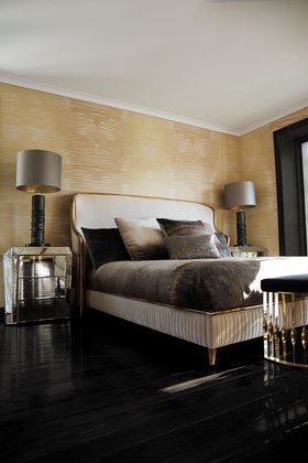 Bedroom | bedding area in art deco style with Forbidden plain bed, Ruchê dark table lamp, Tamara 3 drawers nightstand for storage, beige wallpaper, pillow, and black wood flooring