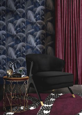 Living Room | cosy elegant reading corner with Naomi curvy dark armchair, Enchanted gold side table in wood, Snake 8 purple animal print rug, nature-inspired wallpaper, and deep plum curtain