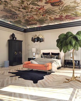 Bedroom | black and white paint bedding area in maximalist style with Forbidden bed, Privê orange daybed, Hypnotic glass and gold chandelier, Parisian dark armoire for storage, rug, pillow, mantle, palm tree, nature-inspired wallpaper, and wood flooring