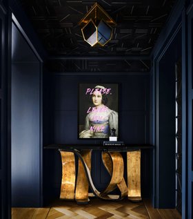 Entryway | deep blue paint hallway in luxury modern style with Ribbon broken gold metallic leaf console, wall art, and wood flooring