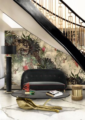 Living Room | spring/summer reading corner in cosy elegant style with Tabu gold and glass center table, Reptilia dark floor lamp, Isabella beige puff, curvy black sofa, nature inspired wallpaper, staircase, and marble flooring