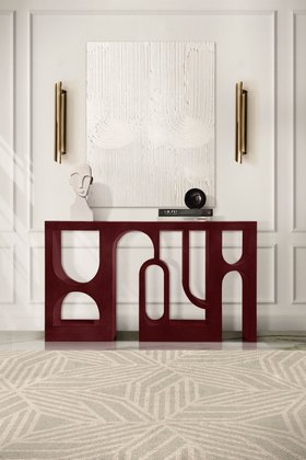 Entryway | white paint hallway in modern classic style with Colosseum curvy deep red console, Cyrus gold wall lamp, Cauca cosy geometric rug, wall art, and decorative accessories