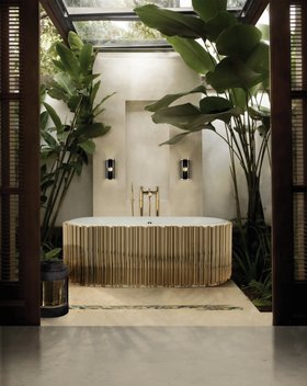 Bathroom | nature inspired bathroom for the spring/summer season with the Symphony gold bathtub, retro dark wall lamp, stool, and white marble flooring