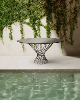 Outdoors | outdoor pool area with Allure smoked glass and iron dining table, stone flooring, and some greenery