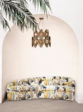 Outdoors | outdoor living area in art deco style with Vamp nature inspired curvy sofa, Vivre 2 rings gold retro chandelier, arcade, and some greenery