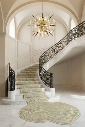 Hallway | white paint entryway in modern classic style with Loode coastal rug spreading along the staircase, Outburst gold chandelier, and marble flooring