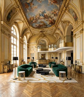 Living Room | gold paint reading corner in mid century modern style with Wales deep green curvy sofa, Cell neutral rug, Mecca side table, Miles retro floor lamp, Ophelia dark marble center table, Monochrome console, ceiling wallpaper, and wood flooring
