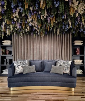 Living Room | spring/summer reading corner in nature-inspired style with Saari curvy klein blue sofa, shelves for storage, cushion, curtain, floral motifs, and wood flooring