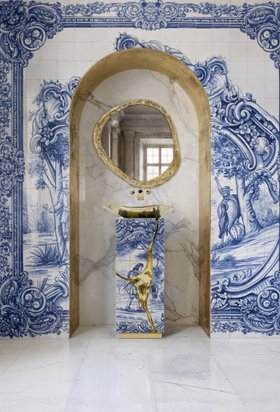 Bathroom | luxury bathroom in portuguese tile with Lapiaz pedestal sink, Lapiaz gold vessel sink, Halo curvy wall mirror, wallpaper, and marble flooring