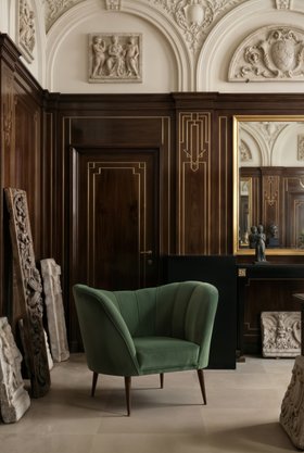 Living Room | luxury reading corner in modern classic style with Andes curvy forest green armchair, brown wood and plaster wall art, and marble flooring