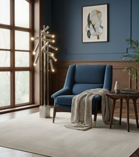 Living Room | deep blue paint reading corner in mic-century modern style with Inca retro armchair, Cyprus gold floor lamp, Brando brown wood side table, White Garden rug, mantle, and wall art