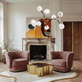 Living Room | spring/summer reading corner in modern classic style with Elk curvy pink armchair, Sequoia brown and gold center table, Horus glass suspension lamp, Blush neutral rug, fireplace, wall art, and wood flooring