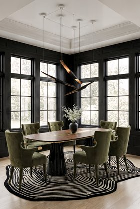 Dining Room | dark paint dining area in mid-century modern style with Sika curvy forest green armchair, Bertoia retro dining table, Coltrane suspension lamp, Loode black rug, and wood flooring