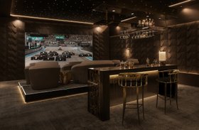 Cinema at Home | dark paint home cinema and bar area in luxury modern style with Nº11 gold bar stool, Pharo table lamp, countertop, and suspended glassware rack