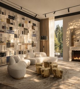Living Room | mid-century modern reading corner with Odette curvy white sofa, Eden gold center table set, Coleccionista bookcase for storage, Miles retro floor lamp, Pantheon neutral rug, fireplace, and curtain